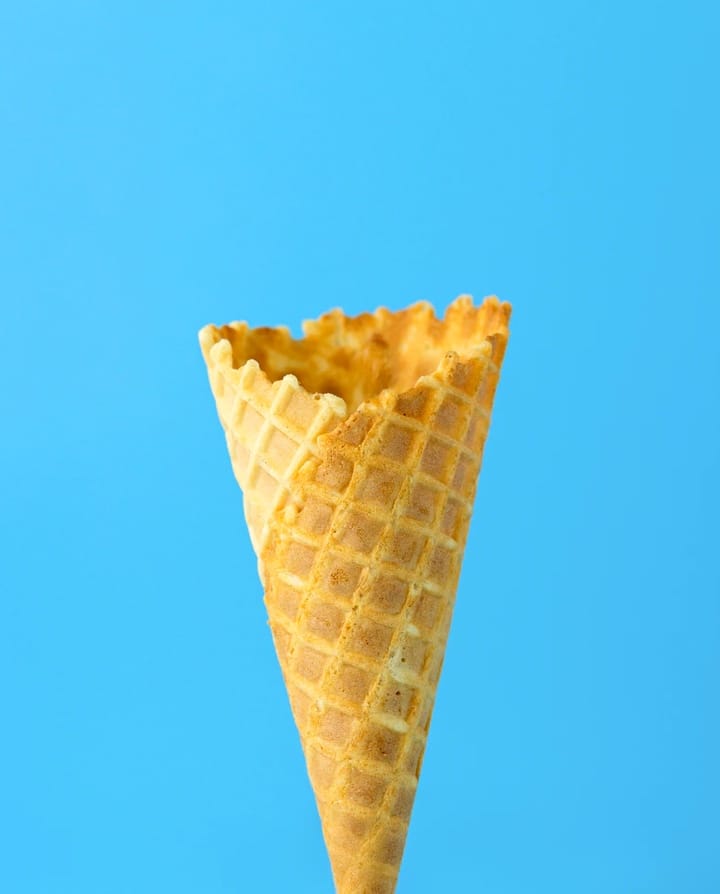 Empty icecream cone over blue background