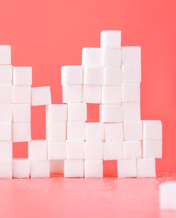 small sugar cubes stacked over a red background