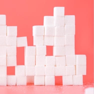 small sugar cubes stacked over a red background